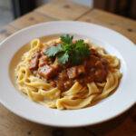 Served Gulasch mit Spätzle with parsley garnish, perfect for a comforting meal.