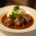 Finished Rinderrouladen served with mashed potatoes and gravy, a classic German dish.